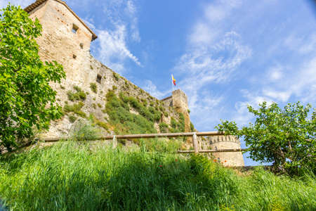 Flowers and plants surrounding a XI century brick walls fortress guarding a small village in the Italian countrysideのeditorial素材