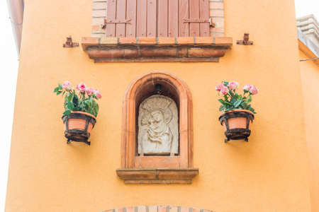medieval streets and ancient memories - Catholic icon of Blessed Virgin Mary with Child Jesus a medieval village in Italy, between historical buildings and private homesの写真素材