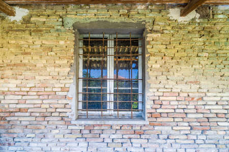 iron bars window in dilapidated brick wall