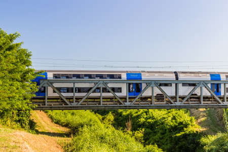 Running train on iron bridge in Italian countryside