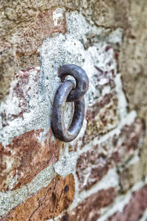 Old iron ring in the brick wall to tie horses or cattleの写真素材