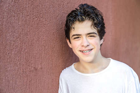 teenager with glamour soft skin smiling while showing braces on red grunge wallの写真素材