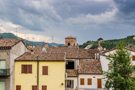 red roofs and grunge walls of ancient buildings and belfry in a country town in the Emilia Romagna region in Italyの写真素材
