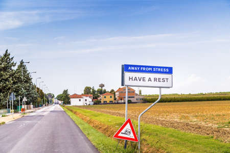 fake road sign of a quiet countryside village inviting to have a rest away from stressの写真素材