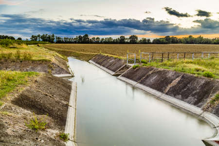 Channel to divert river water for irrigation of cultivated fieldsの写真素材