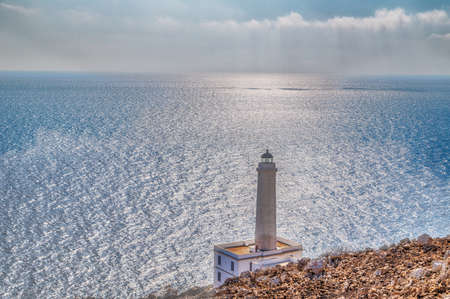 The lighthouse of Cape of Otranto in Apulia standing on hard granite rocks is the most easterly point of Italy and marks the meeting of the Ionian Sea and the Adriatic Seaの写真素材