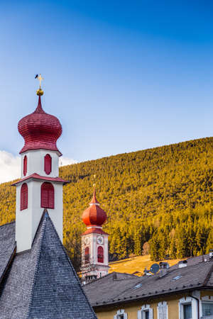 red bell towers of the church of a mountain village in Italyの写真素材