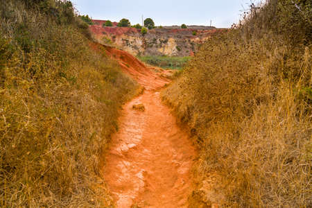 red soils around the freshwater lake formed in a former quarry for the extraction of bauxite in Italyの写真素材
