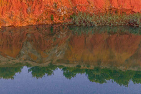 red soils around the freshwater lake formed in a former quarry for the extraction of bauxite in...
