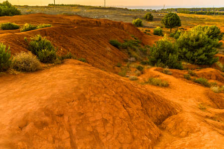 red soils around the freshwater lake formed in a former quarry for the extraction of bauxite in Italyの写真素材