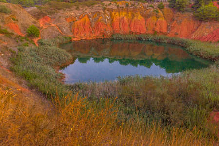 red soils around the freshwater lake formed in a former quarry for the extraction of bauxite in...