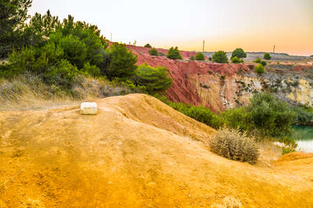 red soils around the freshwater lake formed in a former quarry for the extraction of bauxite in Italyの写真素材
