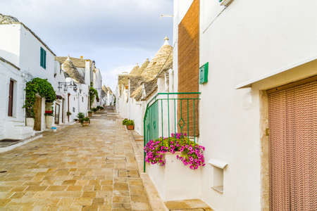 The Trulli of Alberobello in Apulia in Italy. These typical houses with dry stone walls and conical roofs are unique to the world and projecting this place outside of time and reality, somewhere between magic and historyの写真素材