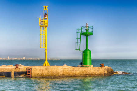 green and yellow lighthouses on a pier on  the Adriatic Seaの写真素材