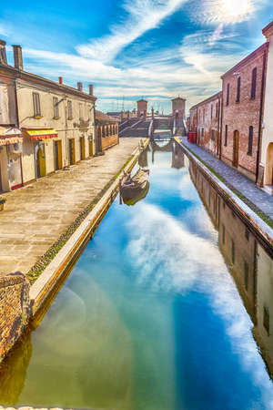 the vibrant colors of the historic homes of Comacchio in Emilia Romagna, an enchanting lagoon cityの写真素材