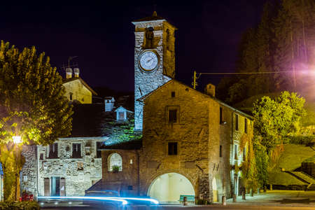 car headlights in the night near The Palace of  the Captains in medieval mountain village in Tuscany...