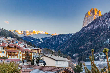 The roofs of a people friendly alpine town in the background of snowy mountains in the Italian Alps
