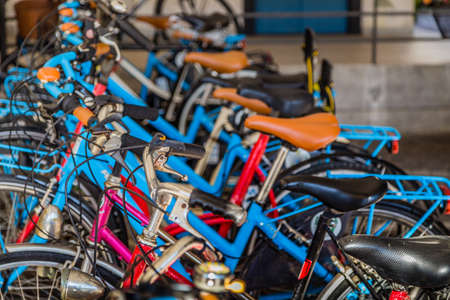 red, orange and blue bicycles parked one next to the otherの写真素材