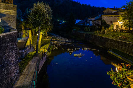 River runs through medieval mountain village in Tuscany characterized by houses with walls of stones derived from the Renaissance. Night viewの写真素材