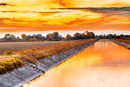 Channel to divert river water for irrigation of cultivated fieldsの写真素材