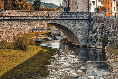 Bridge over the waters of the stream Tramazzo while bathing the hill village of Tredozio in Romagna in the countryside in Northern Italyの写真素材