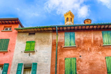 clock tower and rooftops of ancient buildings and brick wall houses in Brisighella, hill village in Emilia Romagna in Italyの写真素材