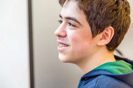 caucasian boy happy and smiling with braces on teeth
