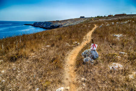 red path on the rocky beach near Otranto in Apulia, Italyの写真素材