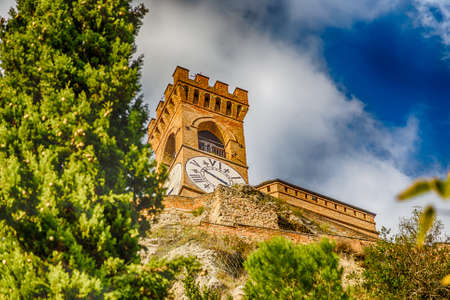 clock tower behind trees in Brisighella in Emilia Romagna, Italyの写真素材