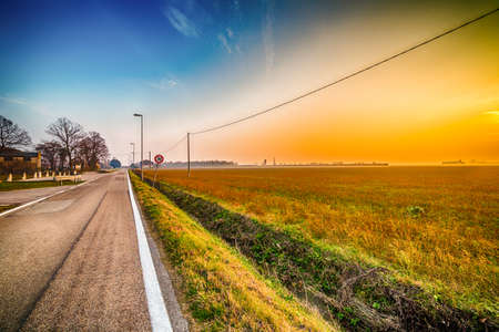 sunset on country road with speed limit signalの写真素材