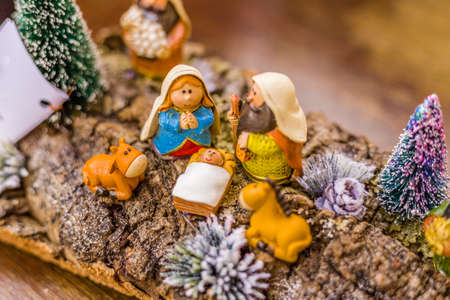 vivid colors of a Christmas Nativity scene, the Blessed Virgin Mary and Saint Joseph watch over the Holy Child Jesus in a manger as the ox and the donkey are warmingの写真素材