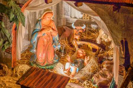 Statues in a Christmas Nativity scene, the Blessed Virgin Mary and Saint Joseph watch over the Holy...