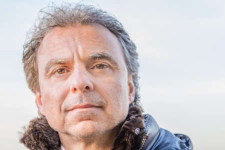 Middle-aged Caucasian man with gray hair dressed in black down jacketの写真素材