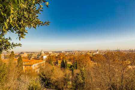 View overlooking the rooftops of Rome, ancient monuments, historic palaces, ancient buildings, Catholic churches and old houses, green trees and orange leavesのeditorial素材