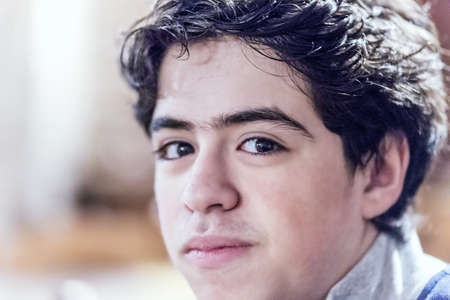 close portrait of Caucasian boy with reassuring look in warm and bright ambianceの写真素材