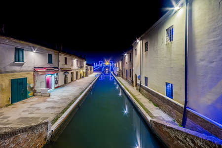 night view of the streets and canals of Comacchio, the little Venice of Emilia Romagna, illuminated by lights and decorations during Christmasの写真素材