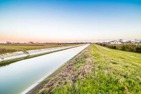 artificial water canal to irrigate the cultivated fields in the countryside of Emilia Romagna in...