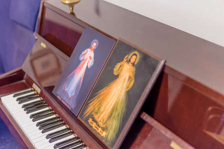 the two icons of the Merciful Jesus on a piano as if they were musical scores: the Italian sentence on the bottoms means Jesus, I Trust in youの写真素材