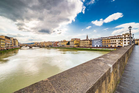 bridges over the Arno river which runs through the historic buildings of Florence in Italyの写真素材