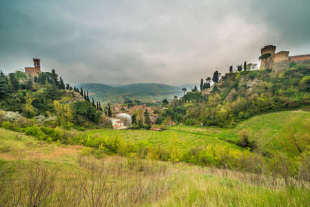 the green countryside around the fortress and the clock tower overlooking Brisighella in the Emilia Romagna in Italyの写真素材
