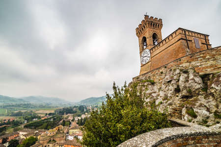 crenellated clock tower above the roofs in the old town of Brisighella in the valley nestled among the hills of Emilia Romagna in Italyの写真素材