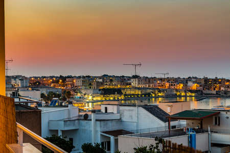 Night view of the roofs of an ancient seaside town in Salento in Apuliaの写真素材