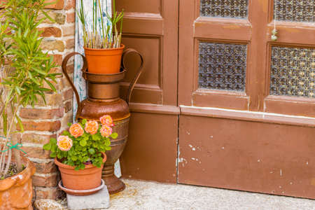 vase of roses near the front door of an old house in Italyの写真素材