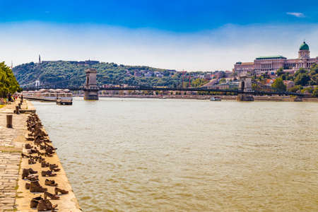 View of the Danube river, including the Chain Bridge under the Royal Castle, the monument to freedom in the Citadel and the Shoes on the bank memorial in Budapestのeditorial素材