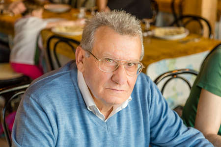 Senior with glasses looks frowning and alteredの写真素材