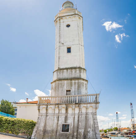 view of  the 18th century lighthouse watching over the canal port, with ancient and modern buildings in Rimini, Italyの写真素材
