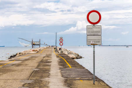 fishermen and fishing shack on the pier with breakwater rocksの写真素材