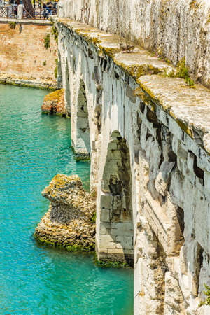 clear water under the arches of the Roman bridge of Augustusの写真素材