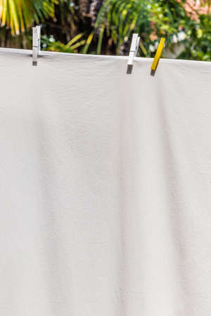 clothes hung out to dry with pegs, but after washing they are still dirtyの写真素材