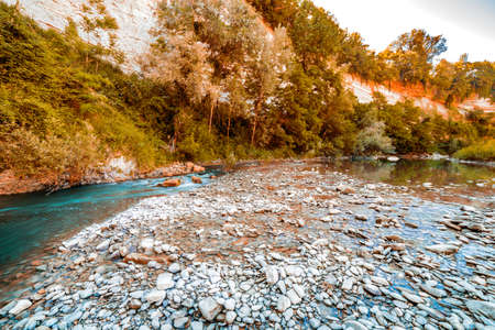 the clear and transparent waters on the bed of a river on the green hills of Emilia Romagna in Italyの写真素材